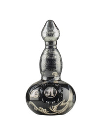 Elegant black decanter-style bottle of AsomBroso Platino Silver Tequila, featuring intricate silver swirl patterns, ornate “A” monogram, and etched “AsomBroso Ultra Fino Tequila Silver” labeling on a glossy, bulbous design with a tapered neck and stopper top.