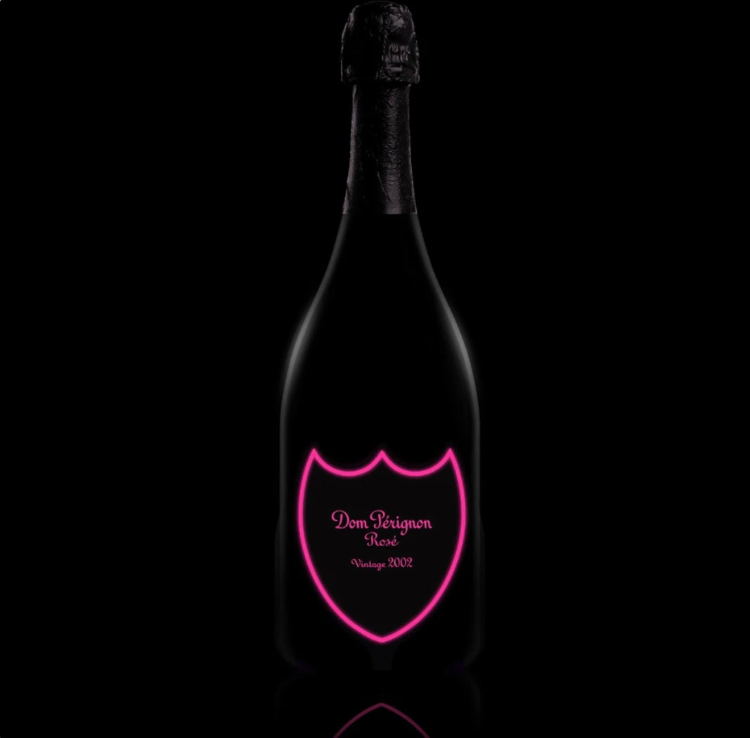 A bottle of Dom Pérignon Rosé Vintage 2008 champagne with a special luminous label that glows in the dark, displayed standing upright. The classic Dom Pérignon branding and vintage year are visible on the front of the bottle.