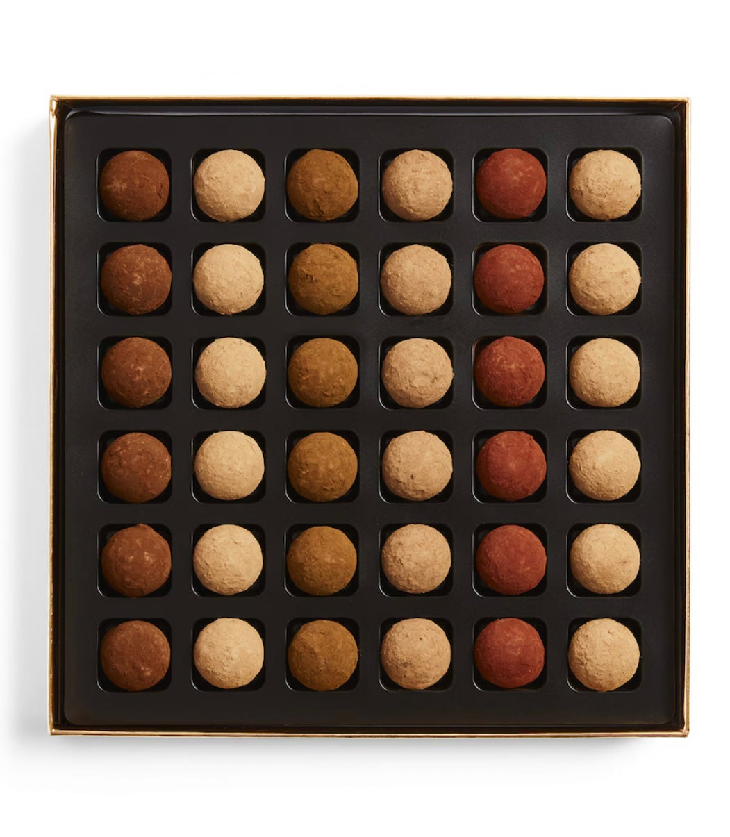 Box of assorted chocolate truffles in a grid pattern on a white background