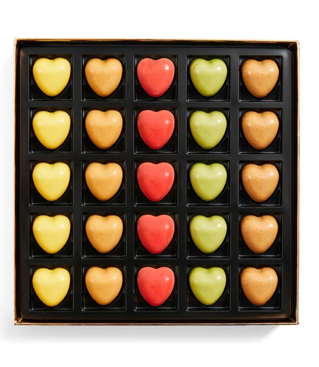 Box of heart-shaped chocolates in various colors on a white background