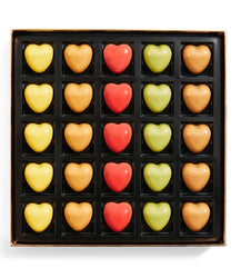 Box of heart-shaped chocolates in various colors on a white background