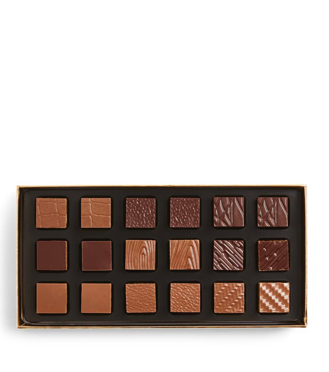 Box of chocolates with various patterns on a white background