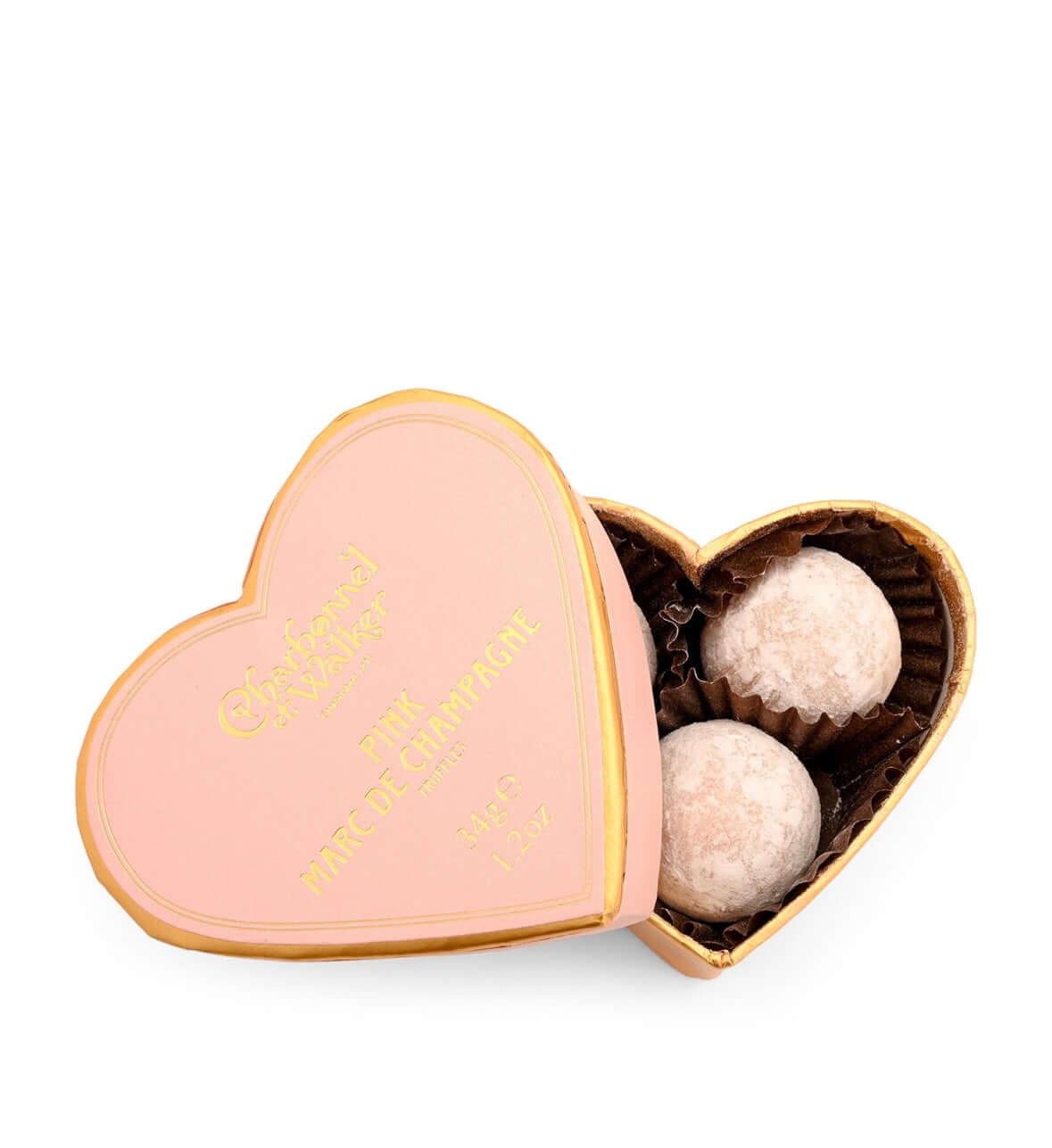 Heart-shaped pink box with gold text containing two white truffles on a white background