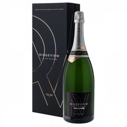 Matte black gift box and large green magnum bottle (150cl) of Ridgeview Blanc de Blancs Limited Release 2009 English sparkling wine. The tall black presentation box features elegant rose-gold geometric line artwork forming an abstract "R" motif, repeated "SUSSEX • ENGLAND" text in gold at the top, "RIDGVIEW LIMITED RELEASE" in white, and "FAMILY OWNED SINCE 1995" in small gold lettering at the base. The bottle has a silver foil capsule, a copper-toned vintage band with "2009" highlighted, and a black label