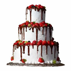 Three-tiered Passion Wedding Cake drizzled with chocolate and topped with fresh strawberries and seasonal fruits.