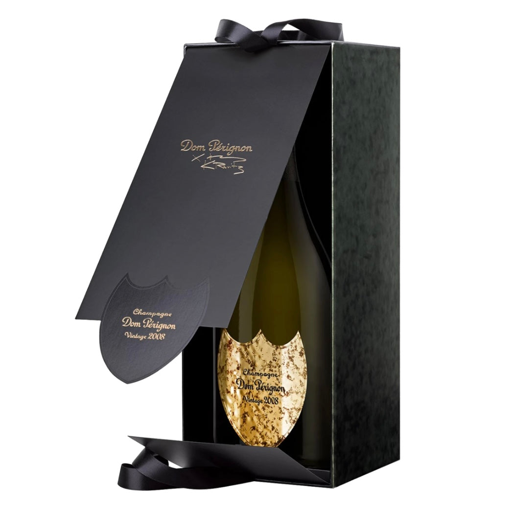 Dom Pérignon Lenny Kravitz Limited Edition Vintage 2008 Champagne presented in an open luxury dark green gift box, revealing the bottle with a gold textured shield label and black ribbon detailing.