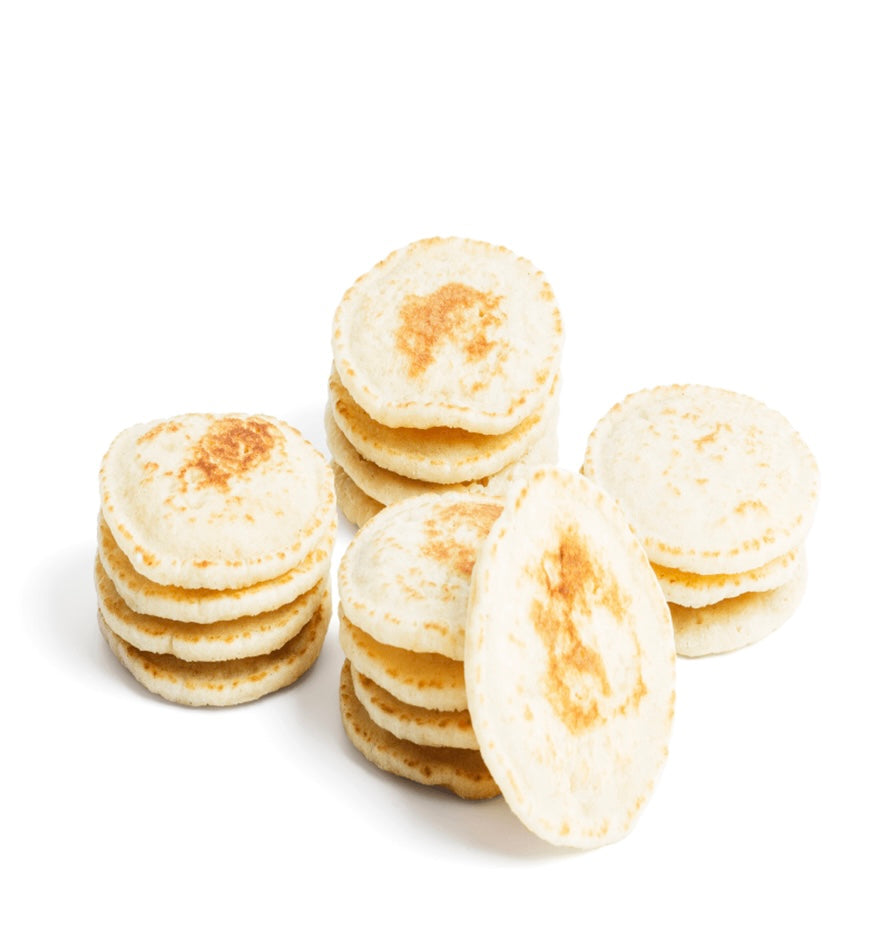 Stack of thin pancakes on a white background