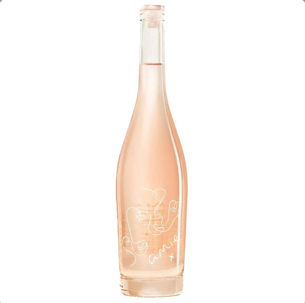 Pale peach-pink bottle of Amie X Organic Rosé 75cl, a premium dry organic rosé from Southern France. The elegant, clear glass bottle features a natural cork closure and a minimalist label with delicate white line-drawn abstract faces forming a heart shape, accompanied by the handwritten-style text 