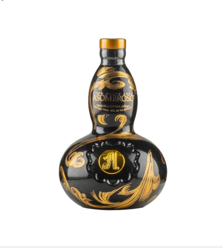 Black ceramic gourd-shaped bottle of AsomBroso Gran Reserva Extra Añejo Tequila with elegant gold swirling floral and wave patterns, gold cap, and a prominent circular gold 'A' medallion on the front, displayed against a plain background.