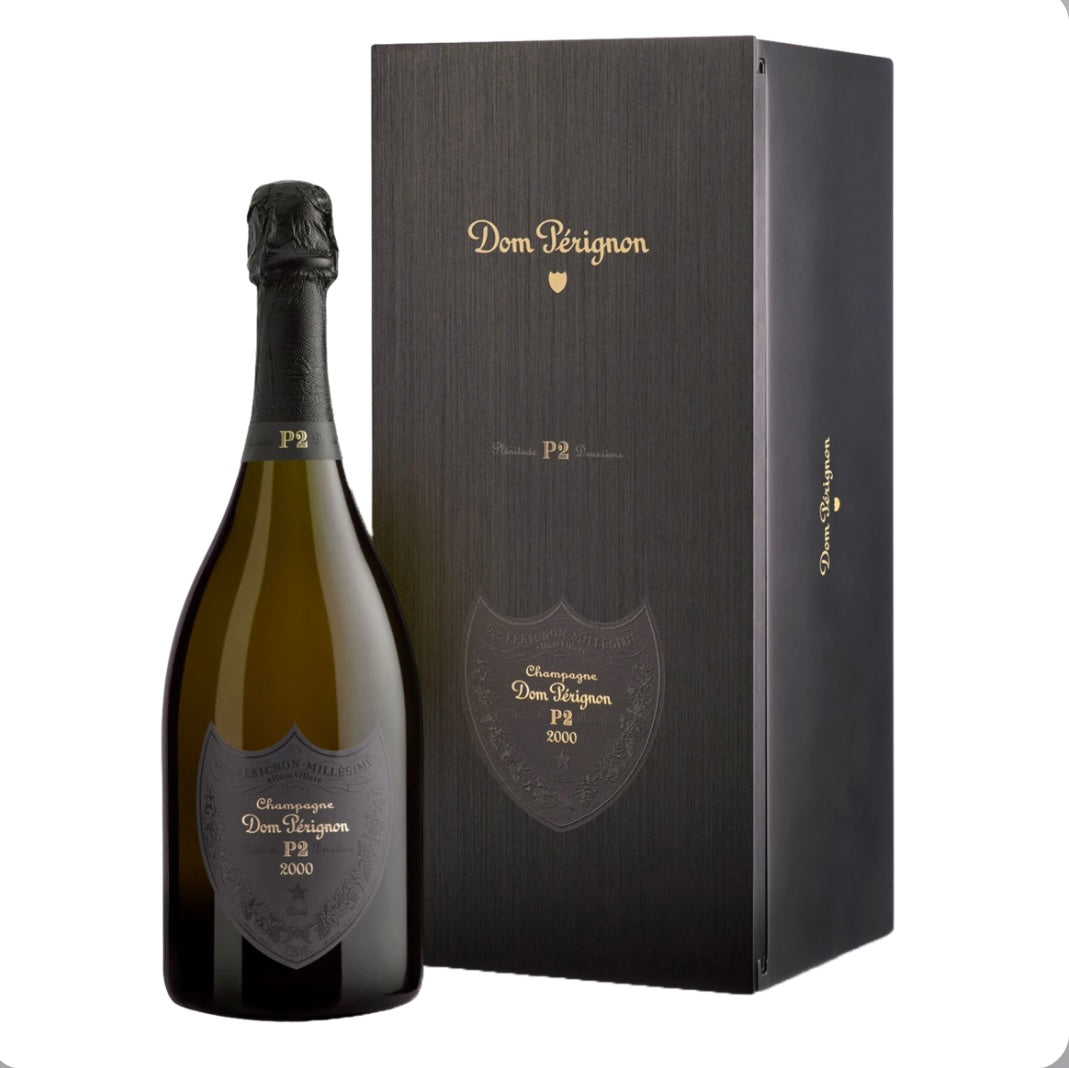 The gift box for Dom Pérignon P2 Vintage 2000, showing the iconic black label with silver typography that denotes the prestigious "Plénitude 2" second life of this mature, complex champagne.