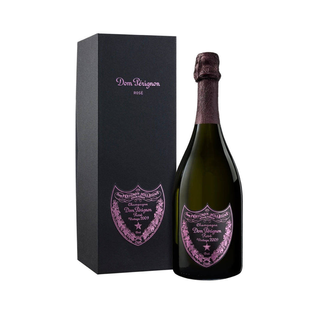 A glossy red gift box containing a bottle of Dom Pérignon Rosé Vintage 2009 champagne. The bottle label prominently features the "Dom Pérignon" and "Rosé" branding against its classic dark glass.