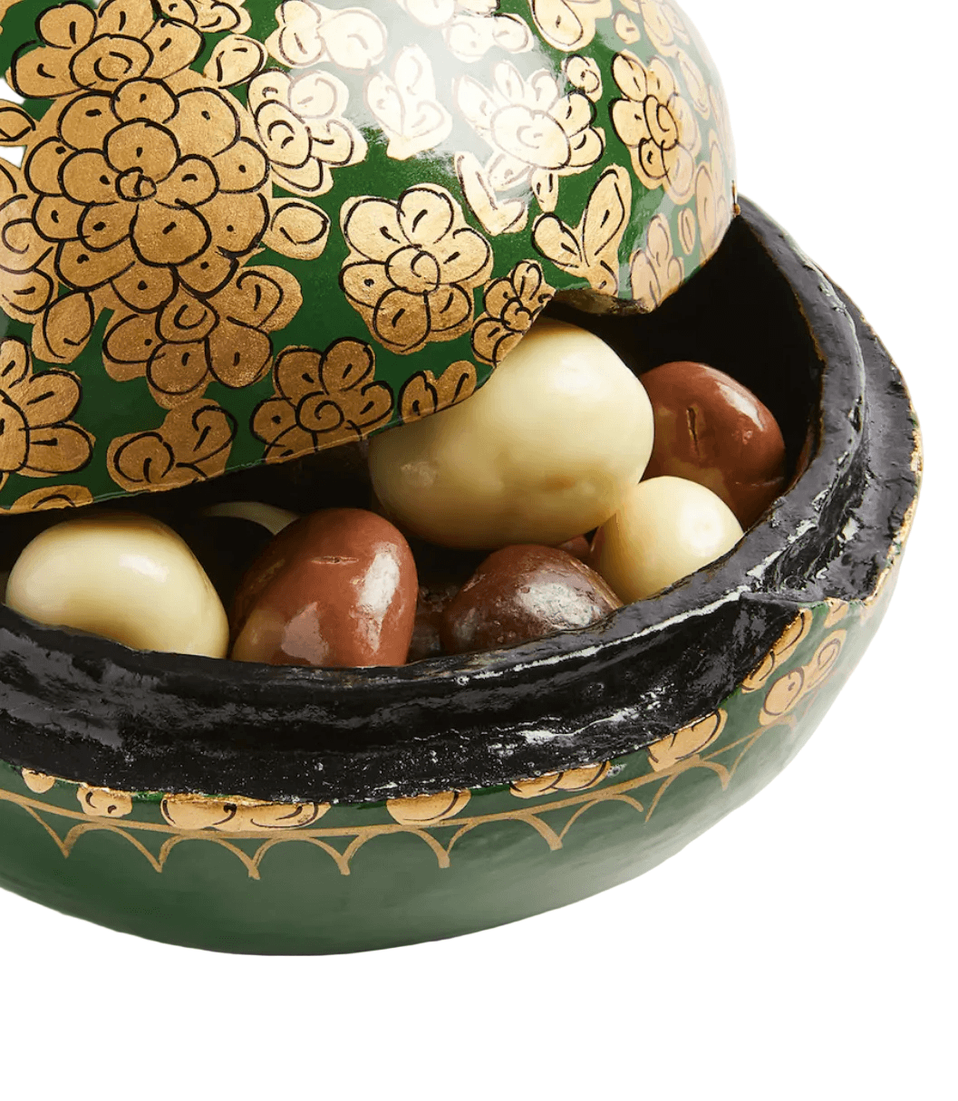 decorative-bowl-with-patterned-lid-containing-marbles-on-a-white-surface
