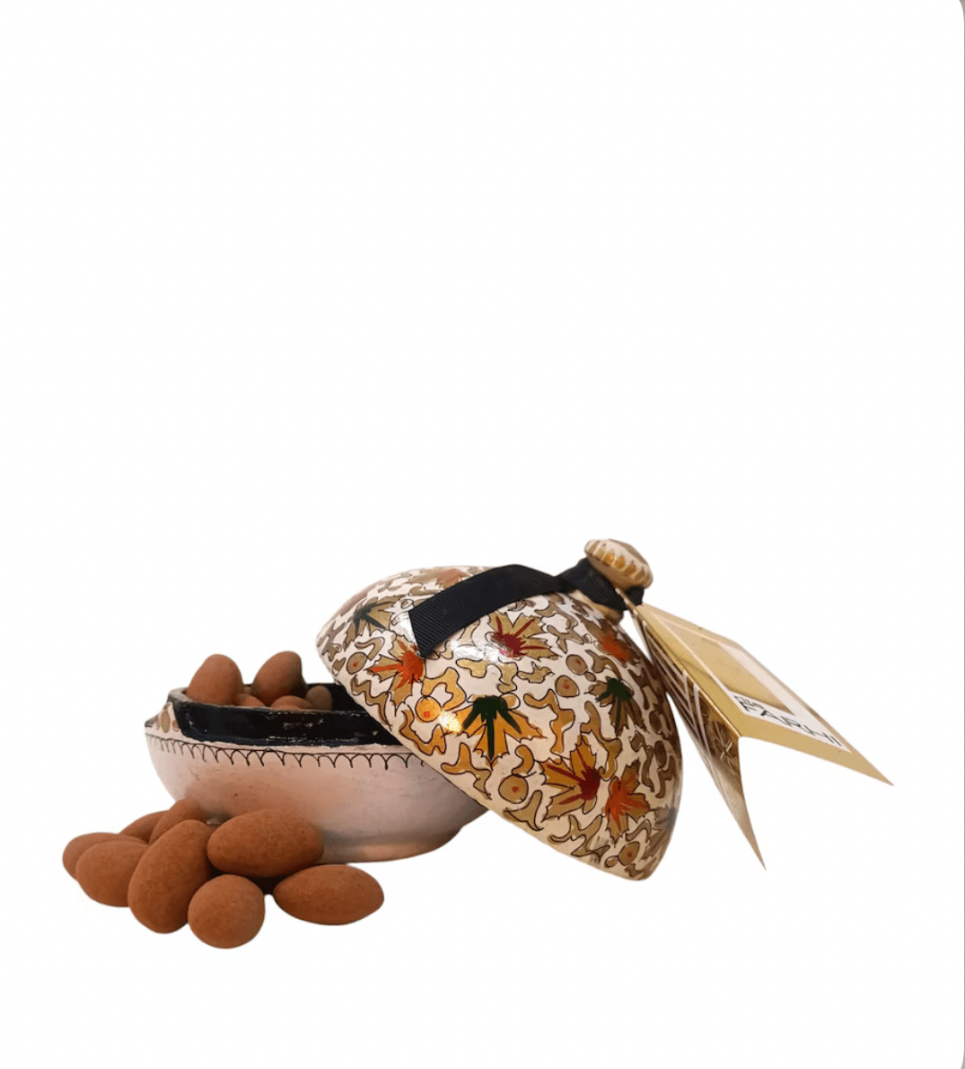 decorative-bowl-with-patterned-lid-and-almonds-on-a-white-background