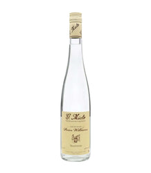 A bottle of St. Miko Peure Williams Tradition spirit distillation liquor, featuring a clear glass bottle, a beige paper label, and a beige foil cap, set against a plain white background.