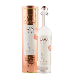 A bottle of Sarpa Poli Grappa alongside its metallic copper-colored cylindrical packaging box, set against a plain white background.