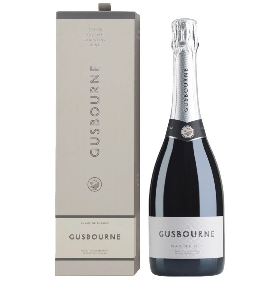 Matte grey gift box and dark green bottle of Gusbourne Blanc de Blancs Vintage English Sparkling Wine (75cl). The tall rectangular gift box has a subtle grey tone with vertical "GUSBOURNE" lettering in silver, "VINTAGE ENGLISH SPARKLING WINE" at the top, and "BLANC DE BLANCS" / "GUSBOURNE" / "TRADITIONAL METHOD PRODUCT OF ENGLAND" in black and grey bands, featuring the small Gusbourne bird emblem. The bottle has a silver foil capsule, a black neck band with the Gusbourne logo, and a clean white label readin