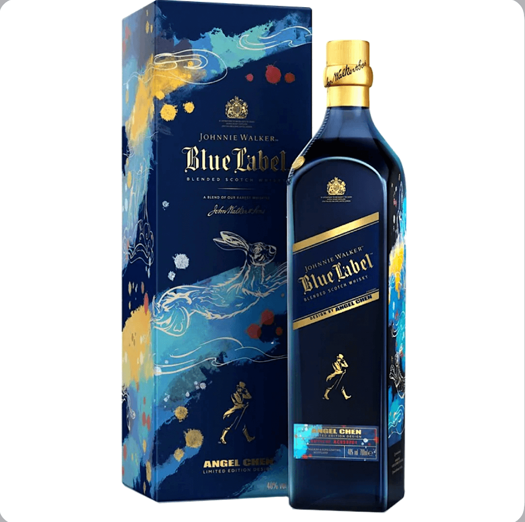 Navy blue bottle and matching gift box of Johnnie Walker Blue Label Limited Edition Year of the Rabbit (70cl / 700ml), a 2023 Lunar New Year collaboration with designer Angel Chen. The matte navy bottle features a glossy black label with gold Johnnie Walker striding figure at the base, a diagonal silver stripe, gold crown emblem, and "Johnnie Walker Blue Label Blended Scotch Whisky" text. Artistic highlights include a stylized golden rabbit leaping through abstract blue, teal, yellow, and red.