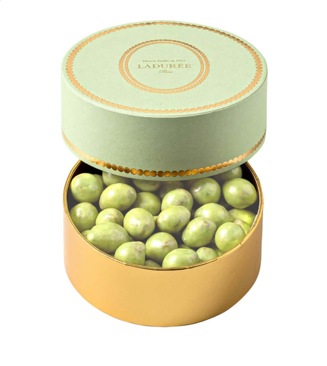 round-green-and-gold-laduree-chocolate-box-with-green-chocolates-inside-on-a-white-background