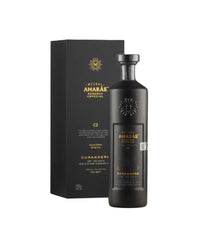 Matte black bottle and black gift box of Mezcal Amarás Reserva Especial Curandero C2 (700ml), a limited-edition Spring 2025 ancestral mezcal from Oaxaca. Sleek matte black glass with embossed gold sunburst logo, gold metallic label text featuring "AMARÁS RESERVA ESPECIAL", "CURANDEROC2", "Limited Edition Spring 2025", "Joven - 100% Agave", "Rare Agave", "Ancestral Mezcal", "45% ALC/VOL", and "HECHO EN SAN PEDRO TOTOMACHAPAM, OAXACA". Matching black box with gold foil Amarás logo and text.