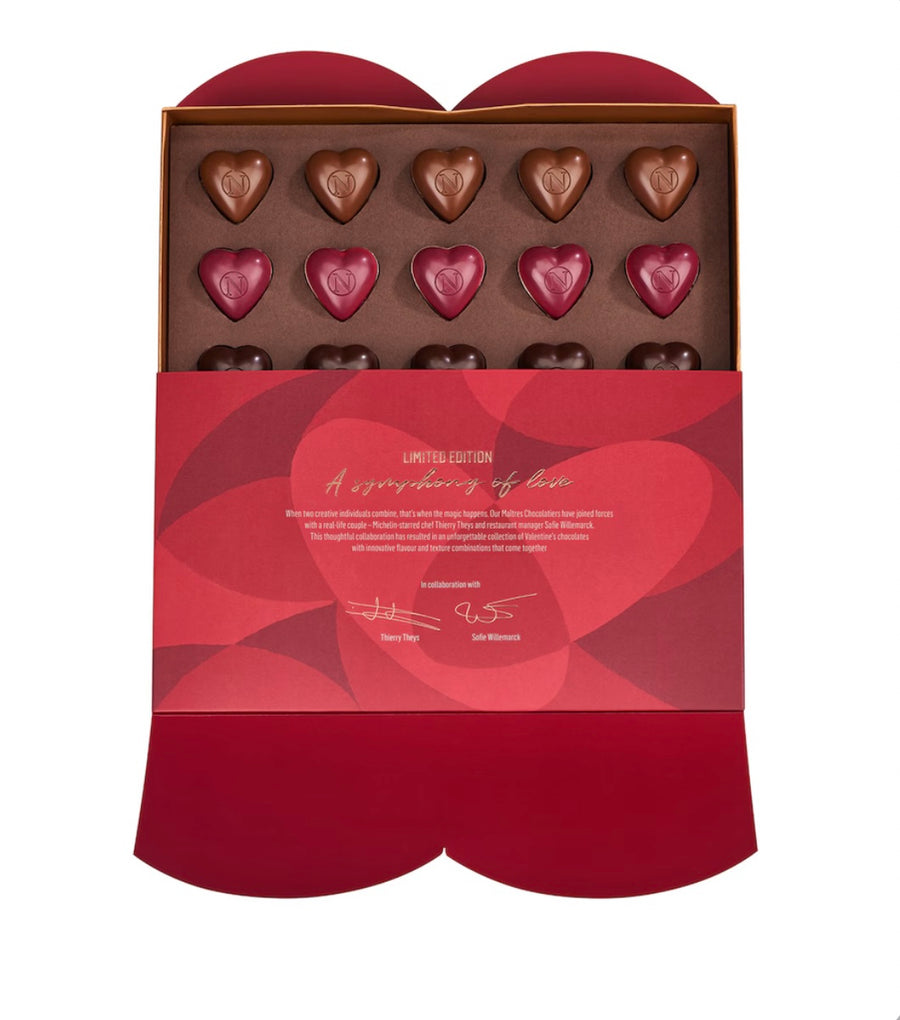 Box of heart-shaped chocolates with a red and gold design on a white background