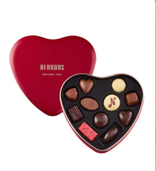 Heart-shaped chocolate tin with Neukäfers chocolates on a white background