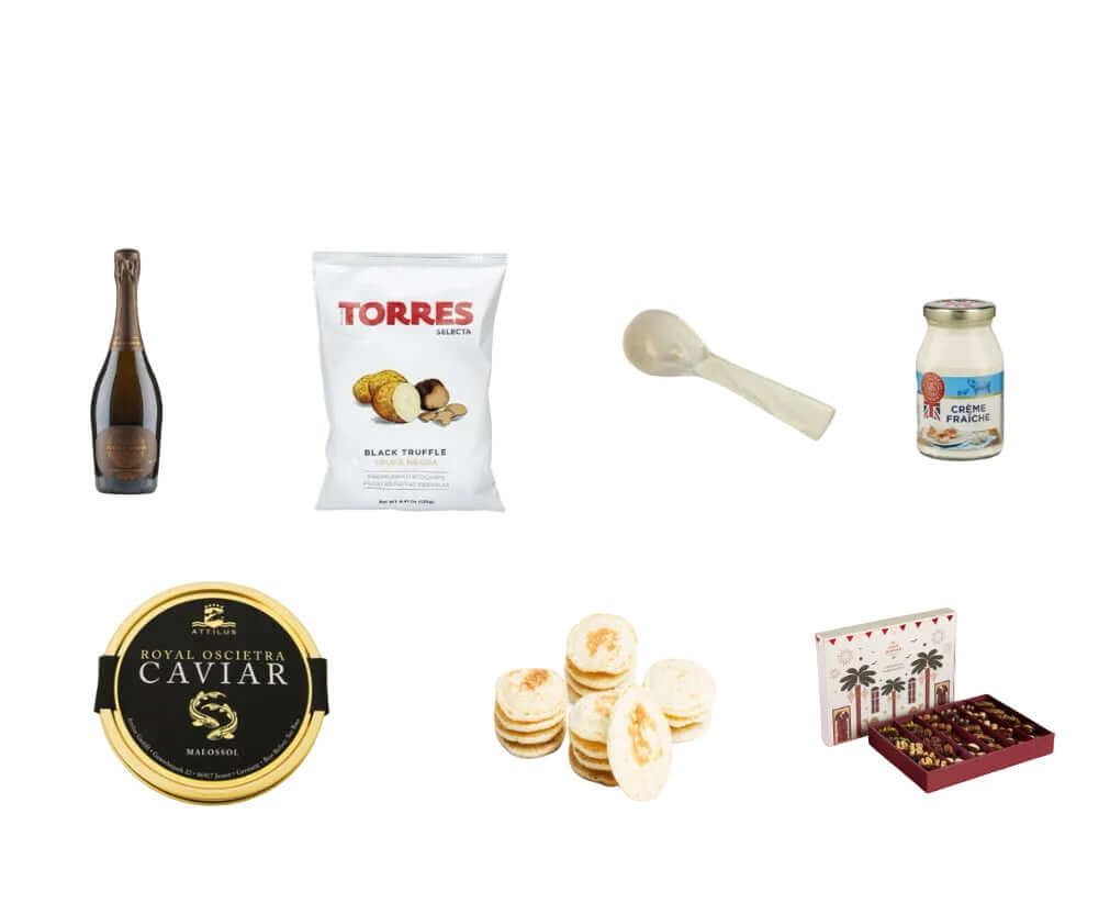 Collection of gourmet items including an alcohol free bottle of Sparkling wine, Caviar, Qinwan Dates and other food products on a white background.