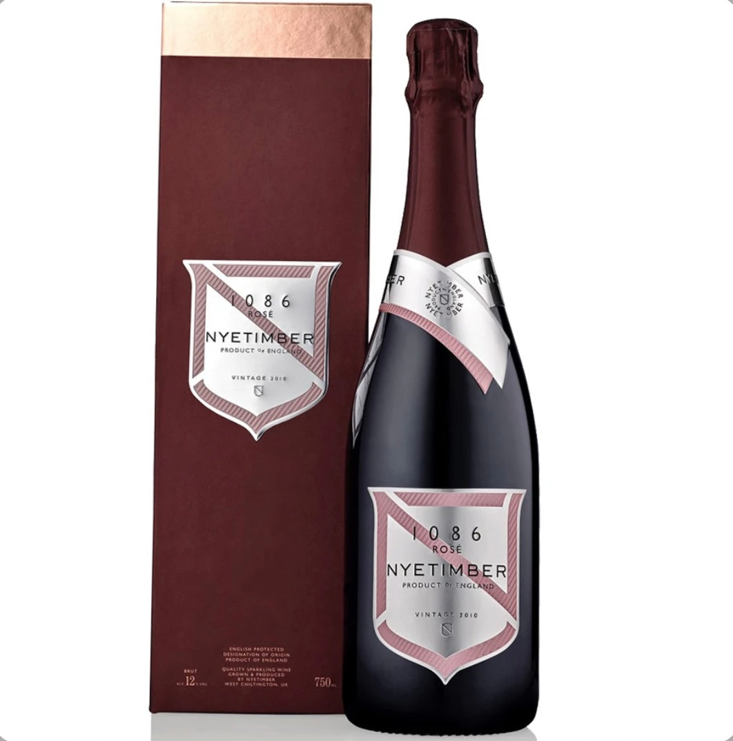 Dark burgundy bottle and matching burgundy gift box of Nyetimber 1086 Rosé Vintage 2010 English sparkling wine (75cl / 750ml). The bottle has a deep red foil capsule, a silver neck band with 