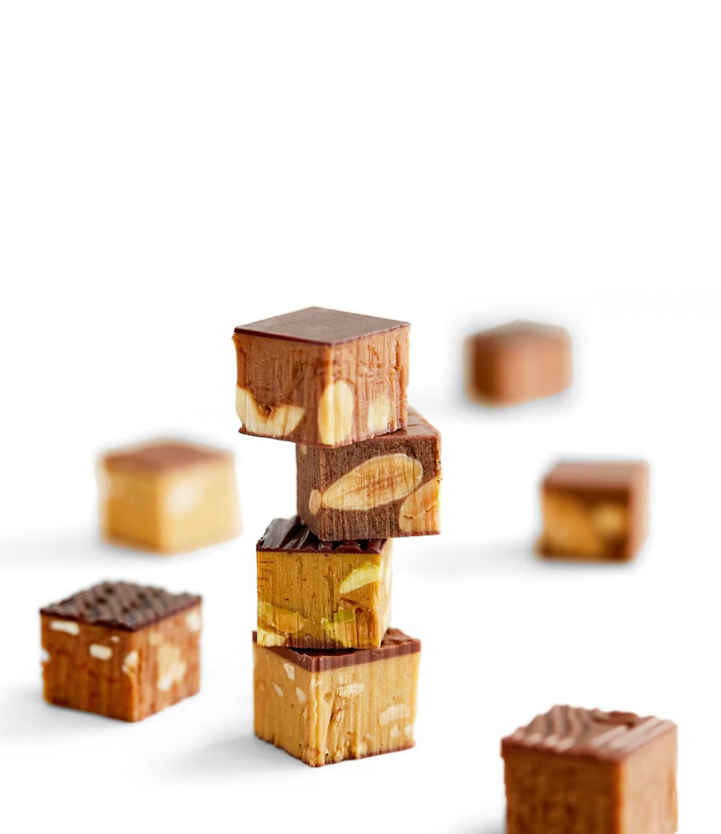 Stack of chocolate-covered treats with nuts on a white background