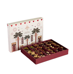 Gift box of Qinwan Dates with a decorative lid featuring palm trees and a red base containing assorted chocolates.