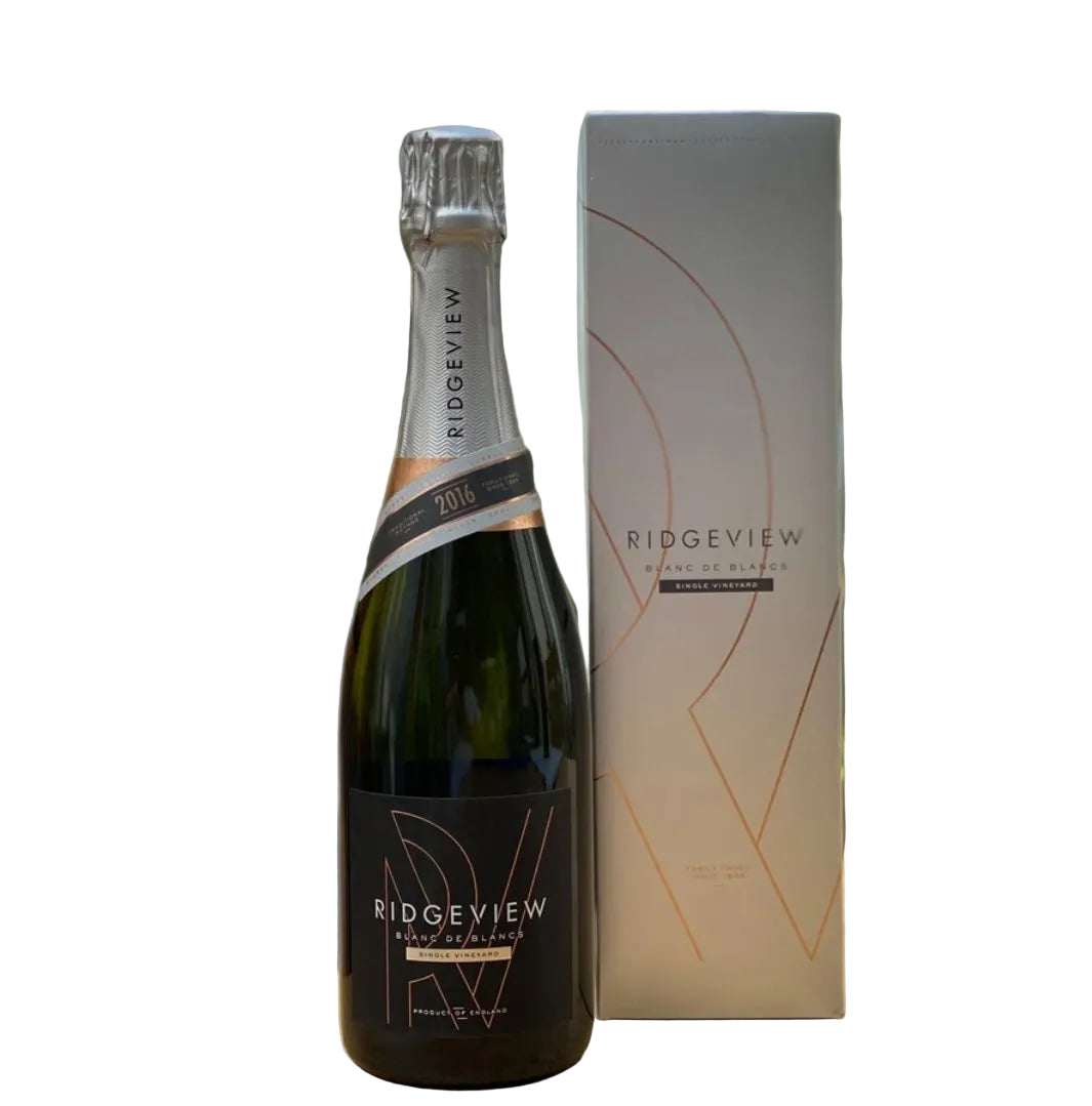 Dark green bottle of Ridgeview Blanc de Blancs Single Vineyard 2016 English sparkling wine (75cl), with a silver foil capsule and black label featuring rose-gold geometric "RV" monogram design, "RIDGEVIEW", "BLANC DE BLANCS", "SINGLE VINEYARD", and "2016" vintage band in copper and black. Displayed next to its tall matte silver-grey gift box with subtle orange geometric line artwork and "RIDGEVIEW BLANC DE BLANCS SINGLE VINEYARD" text in black.