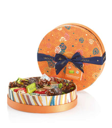 Round candy tin with a decorative lid featuring a bow, filled with assorted candies.