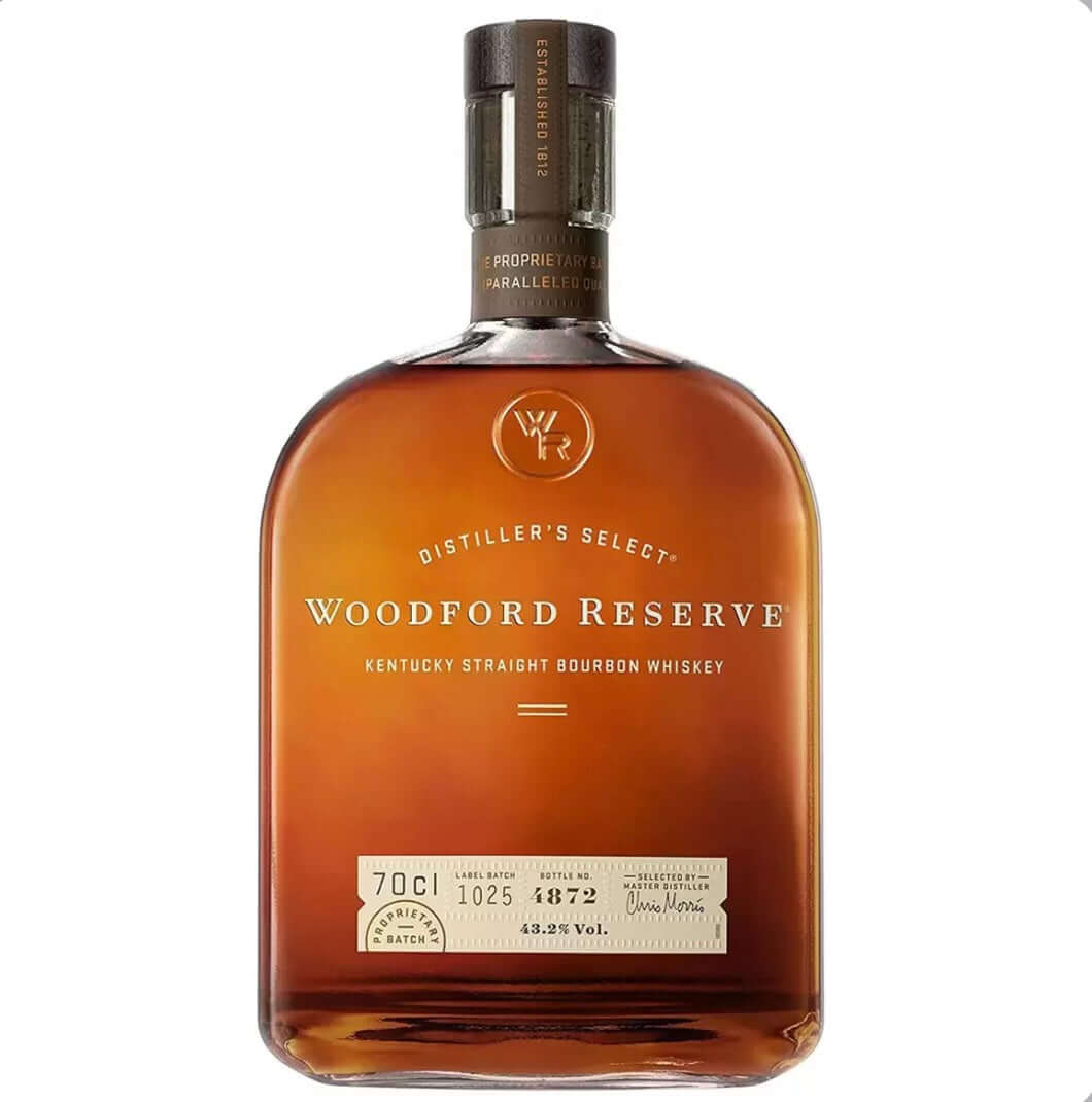 Amber glass bottle of Woodford Reserve Distiller's Select Kentucky Straight Bourbon Whiskey with a distinctive rounded, barrel-like shape and warm copper-brown liquid. The bottle features a dark gray foil capsule with embossed text, a prominent label with "WOODFORD RESERVE" in elegant uppercase gold lettering, "DISTILLER'S SELECT" arched above, and "KENTUCKY STRAIGHT BOURBON WHISKEY" below. 
