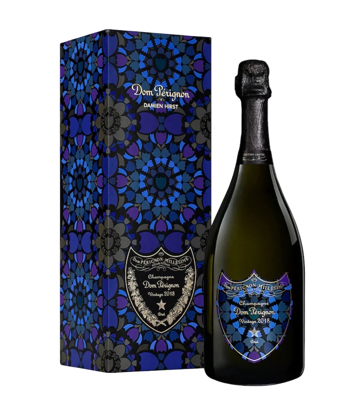 A bottle of Dom Pérignon X Damien Hirst Champagne 2018 displayed next to its matching patterned gift box. The packaging features a dark blue and purple stained-glass style design with gold lettering, and the bottle has a matching decorative label.